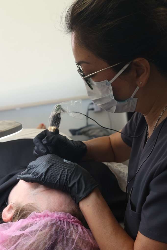 Cindy concentrating during a permanent makeup procedure.